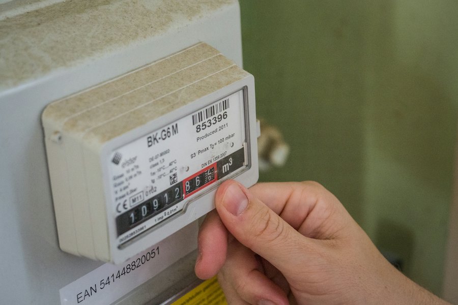 Hand vid en energimätare som mäter strömförbrukningen