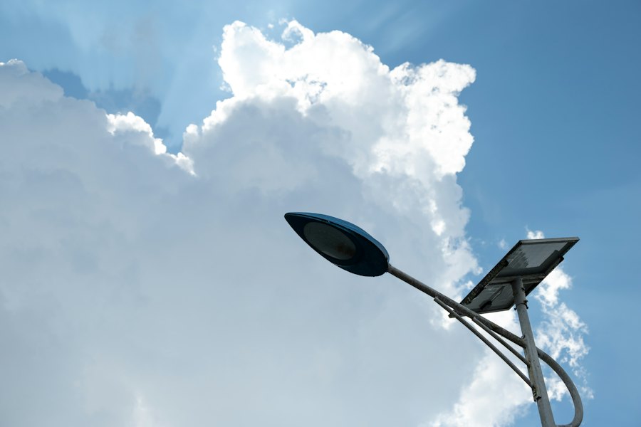 Solcellsdriven gatlykta med solpanel mot en blå himmel